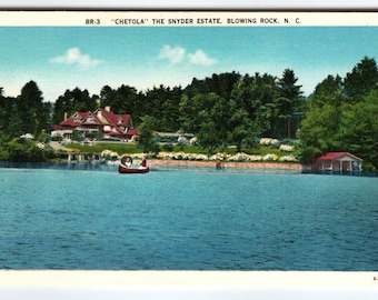 May include: Vintage postcard featuring "Chetola" The Snyder Estate in Blowing Rock, N.C. The image shows a lake with a small boat, a large house with a red roof, and lush green trees under a blue sky. The postcard has a white border.