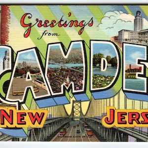 以下が含まれることがあります： 「Greetings from Camden New Jersey」と書かれたヴィンテージポストカード。 「Camden」の文字が中心で、文字の中に街の風景が描かれています。 デラウェア川の橋も描かれています。