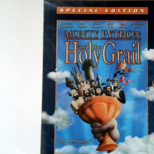 May include: A DVD case for the film "Monty Python and the Holy Grail." The cover shows a blue sky background with an orange chalice holding several characters. The title is in large orange letters, with "Special Edition" at the top.