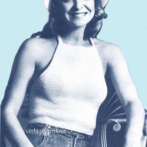 May include: A white crochet halter top with a crocheted white hat with a flower accent. The model is wearing blue jeans.