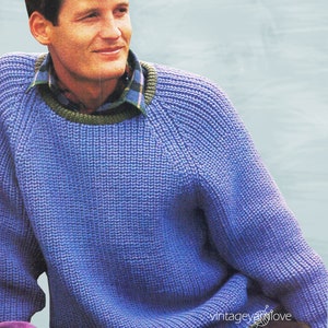 May include: A blue knitted sweater with a green and brown trim around the neck. The sweater has a relaxed fit and a round neckline.