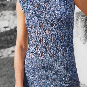 May include: A blue crochet dress with a lacy pattern. The dress has a scoop neckline and sleeveless design. The model is wearing a white bikini top underneath the dress.