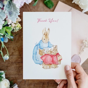 May include: A thank you card featuring a watercolor illustration of Peter Rabbit and two other rabbits. The card has a pink "Thank You!" message at the top.