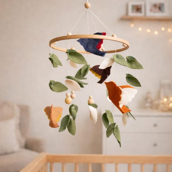 Móvil para cuna con pájaros y hojas de fieltro, decoración neutra inspirada en la naturaleza.
