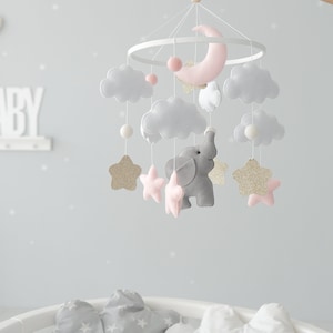 Introducing our Elephant Baby Crib Mobile, a perfect addition to your elephant nursery decor, showcasing delightful pink accents and golden glitter stars for a whimsical and enchanting ambiance.