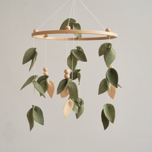 Adorable Forest Baby Crib Mobile - Olive and Beige Leaf Design for a Whimsical Nursery. 
Charming Baby Mobile with Wooden Balls - Enhance Your Woodland Nursery Decor.