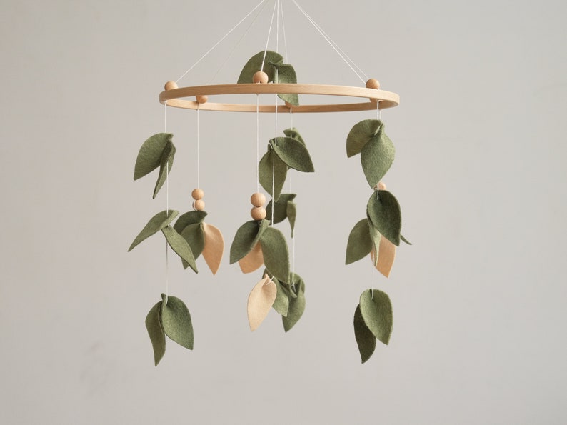 Adorable Forest Baby Crib Mobile - Olive and Beige Leaf Design for a Whimsical Nursery. 
Charming Baby Mobile with Wooden Balls - Enhance Your Woodland Nursery Decor.