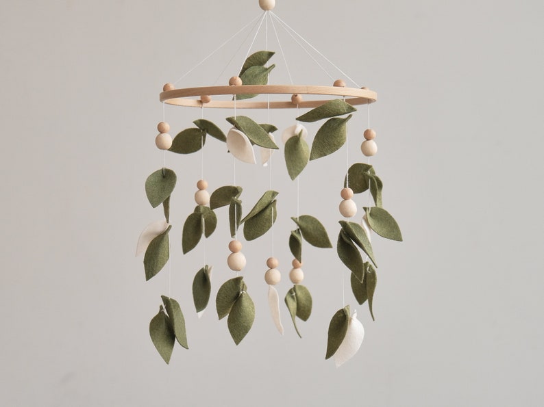 Elegant felt olive leaf baby mobile with wooden accents, inspired by the serenity of the forest, perfect for a nature-themed nursery. This baby crib mobile will perfectly match to your boho neutral nursery.