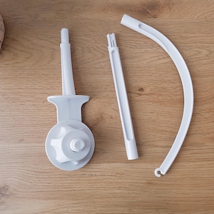 May include: Three white plastic pieces for a baby mobile. The pieces include a base with a knob, a straight rod, and a curved rod.