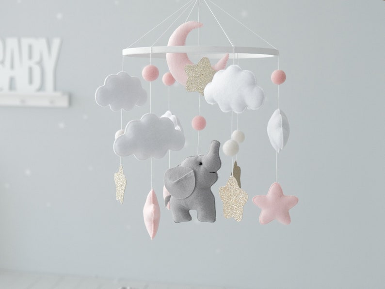 Adorn your baby girl nursery with our Elephant Baby Mobile, showcasing sweet pink hues and golden glitter stars for a touch of elegance and whimsy