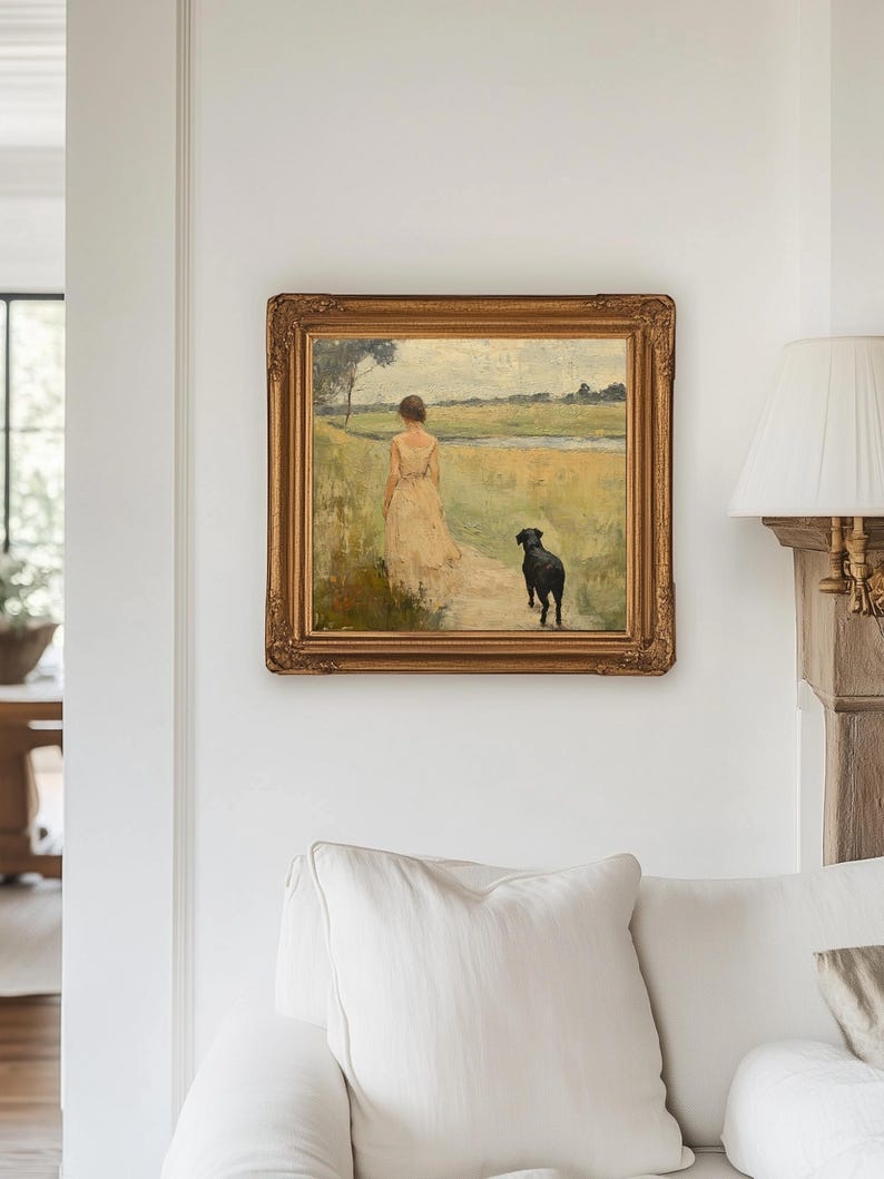 May include: A framed oil painting depicting a woman in a white dress walking with a black dog in a field. The painting is set against a backdrop of a green field and a blue sky.