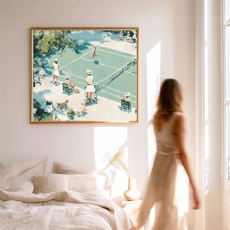 May include: A framed art print depicts a tennis match scene in a vintage style. The artwork features players in white attire, spectators, and dogs on a green court. The frame is gold, and the overall color palette is soft and muted.