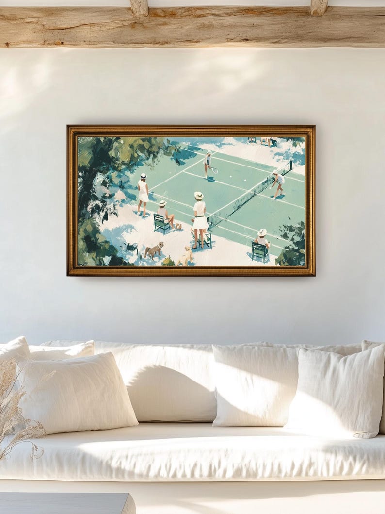 May include: A framed art print depicting a tennis match scene. The artwork features players in white attire on a green court, surrounded by trees and spectators. The frame is gold-toned, and the overall aesthetic is vintage.