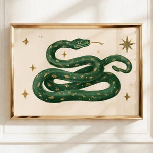 Peut inclure: Une impression d'art encadrée représentant un serpent vert foncé avec des accents de feuilles d'or enroulé au centre. Le fond est de couleur crème clair, décoré de plusieurs étoiles dorées de tailles variées dispersées autour du serpent.