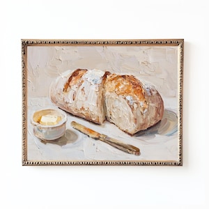 Puede incluir: Pintura al óleo de una hogaza de pan cortada por la mitad, un plato pequeño de mantequilla y un cuchillo. El pan tiene una corteza de color marrón dorado y un interior blanco. La pintura está en un marco dorado adornado.