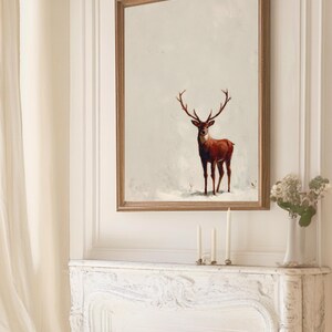 May include: A framed art print featuring a majestic deer with large antlers. The deer is depicted in shades of brown and red against a neutral background. The artwork is encased in a wooden frame, adding a touch of rustic elegance to the wall decor.
