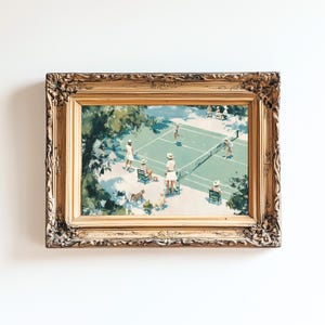 May include: A framed vintage print depicts a tennis match on a green court. Players in white attire are positioned around the net, with spectators in chairs. The ornate gold frame adds a classic touch to the artwork, set against a white background.