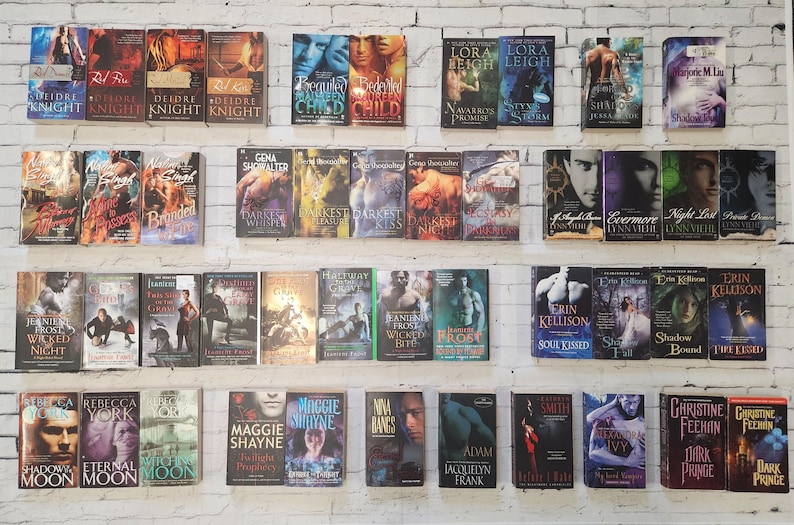 May include: A shelf filled with paperback books, mostly romance novels. The books are arranged in rows and are all different colors. Some of the titles include "Branded", "Darkest Kiss", "Evermore", "Soul Kissed", "Shadow Bound", "Dark Prince", and "Shadow Moon".