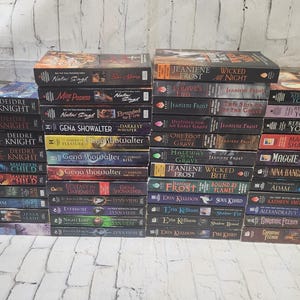May include: A stack of paperback books with various titles and authors. The books are arranged in a vertical stack, with the spines facing outward. The books are all different colors and have different designs on their covers.