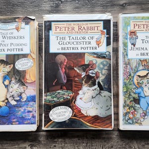 May include: Three VHS tapes from The World of Peter Rabbit and Friends series by Beatrix Potter. Titles include The Tale of Samuel Whiskers, The Tailor of Gloucester, and The Tale of Tom Kitten and Jemima Puddle-Duck, each featuring colorful illustrations.