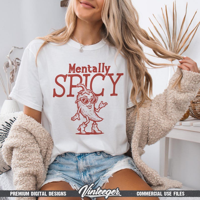 May include: White t-shirt with the text "Mentally Spicy" in red, featuring a cartoon chili pepper wearing sunglasses and boots. The shirt is paired with denim shorts.