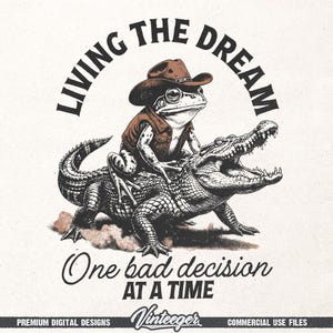 Puede incluir: Ilustraci&oacute;n caprichosa de una rana con sombrero y chaleco de vaquero montando un caim&aacute;n. El texto "LIVING THE DREAM" est&aacute; arqueado sobre la rana, con "One bad decision AT A TIME" debajo. Dise&ntilde;o de estilo vintage.