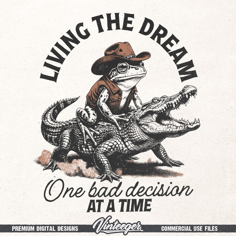 Puede incluir: Ilustraci&oacute;n caprichosa de una rana con sombrero y chaleco de vaquero montando un caim&aacute;n. El texto "LIVING THE DREAM" est&aacute; arqueado sobre la rana, con "One bad decision AT A TIME" debajo. Dise&ntilde;o de estilo vintage.