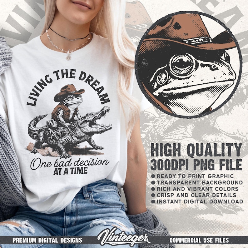 Puede incluir: Camiseta blanca con un dise&ntilde;o de una rana con sombrero de vaquero montando un caim&aacute;n, con el texto "Living the Dream" y "One bad decision at a time." El dise&ntilde;o incluye un gr&aacute;fico circular de la rana. Tambi&eacute;n incluye el texto "High Quality 300DPI PNG File."