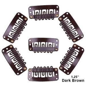 Puede incluir: Seis clips de extensión de cabello marrón oscuro, cada uno con una fila de dientes de metal. Los clips están dispuestos en un círculo, con los dientes hacia adentro. El texto "1.25" y "Marron oscuro" es visible en la parte inferior de la imagen.