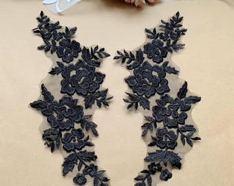 May include: Two navy blue floral lace appliques. Each applique features detailed embroidered flowers and leaves on a sheer mesh backing. The appliques are ideal for embellishing garments or craft projects.