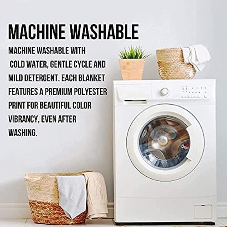 May include: White washing machine with a closed door and a basket of laundry in front of it. The text on the wall reads "MACHINE WASHABLE" and includes instructions for washing the blanket.