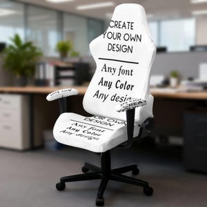 Könnte beinhalten: Ein weißer Gaming-Stuhl mit schwarzem Text auf der Rückenlehne und Sitzfläche, der CREATE YOUR OWN DESIGN, Any font, Any Color, Any design lautet. Der Stuhl hat schwarze Armlehnen und ein schwarzes Fünf-Punkt-Fußkreuz mit Rollen.