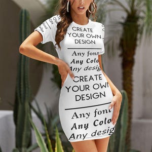 May include: A white short-sleeved mini dress featuring black printed text that reads CREATE YOUR OWN DESIGN, Any font, Any Color, and Any design. The garment has a round neckline and a fitted silhouette that reaches above the knee.