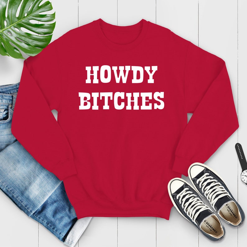 May include: Red sweatshirt with white text that reads "HOWDY BITCHES".