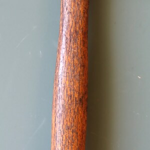 May include: A vintage hammer with a wooden handle and a rusty metal head. The hammer has a worn, weathered look and is a classic tool.