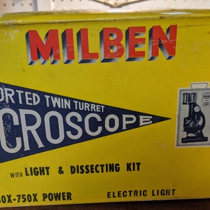 May include: Yellow box with a red and black logo that says "MILBEN" and the text "IMPORTED TWIN TURRET MICROSCOPE WITH LIGHT & DISSECTING KIT 80X-750X POWER ELECTRIC LIGHT". The box has a picture of a microscope and a set of tools.