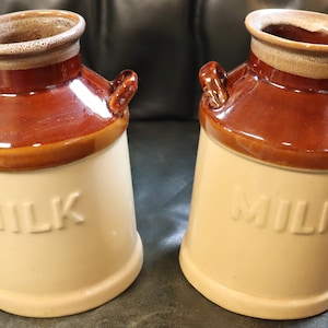 Vintage set of 2 milk can  stoneware with raised letters 7 by 4 1/2 inches