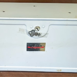 May include: White metal storage box with a lock and key. The box has a label that reads "HANDI-CLEAN PRODUCTS GREENSBORO, N.C."