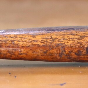 May include: A hammer with a wooden handle and a metal head. The hammer has a brown wooden handle with a textured surface and a black metal head.