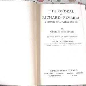 May include: An open hardcover book displaying the title page for The Ordeal of Richard Feverel, A History of a Father and Son by George Meredith, edited by Frank W. Chandler, published by Charles Scribner's Sons in New York, Chicago, Boston, Atlanta, San Francisco, and Dallas.