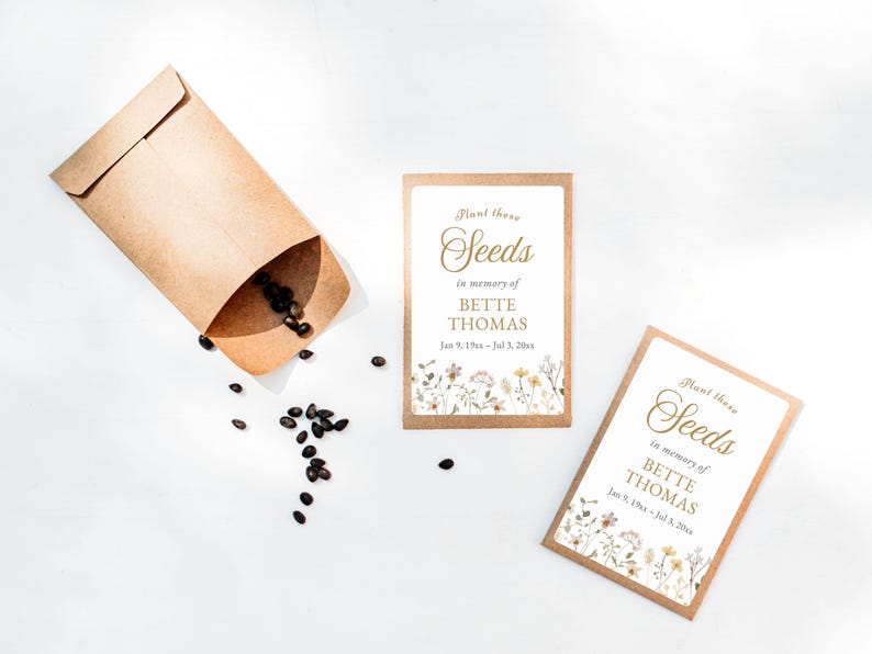 May include: Seed packets with the text "Plant these Seeds in memory of BETTE THOMAS" and floral accents. A kraft paper envelope is open, with seeds spilling out onto a white surface. The dates Jan 9, 19xx - Jul 3, 20xx are also included.