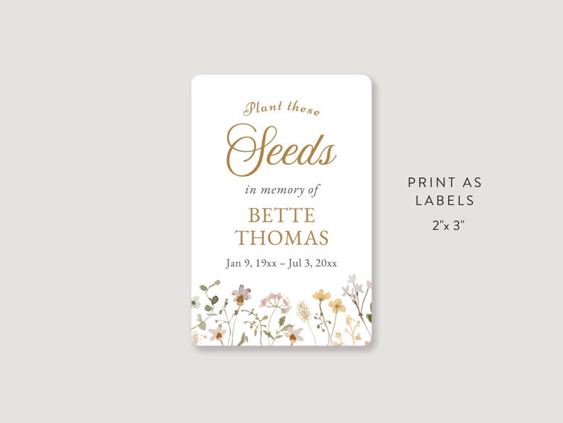May include: A rectangular label with rounded corners, featuring the text "Plant these Seeds" in gold script. Below, it reads "in memory of BETTE THOMAS" and dates. Floral accents border the bottom. The label is 5.08cm x 7.62cm.