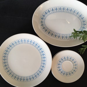 Może przedstawiać: Trzy białe ceramiczne talerze z niebieskim wzorem kwiatowym. Talerze są w różnych rozmiarach, największy jest owalny.