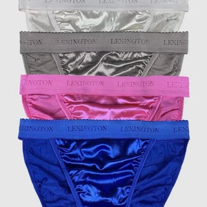 Puede incluir: Un conjunto de cinco pares de ropa interior de satén en negro, plateado, gris, rosa y azul. Cada par tiene una cintura elástica de contraste con la palabra "LEXINGTON" impresa en ella.
