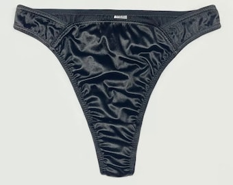 Puede incluir: Tanga de encaje de satén negro con una textura suave y sedosa.