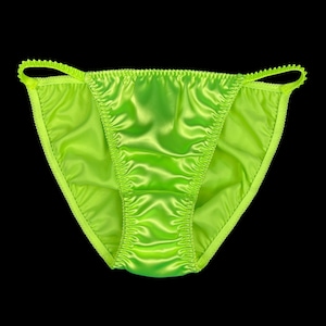 Puede incluir: Un conjunto de lencería de satén verde brillante con un delicado borde de encaje.