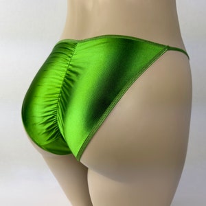 May include: Green satin underwear with a low rise and a cheeky cut. The underwear has a gathered back and thin straps.