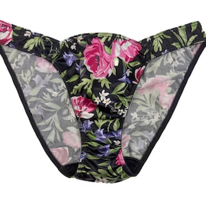 May include: Black floral print underwear with a delicate lace trim. The underwear has a low rise and a cheeky cut.