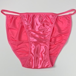 Peut inclure: Lingerie en satin rose avec une coupe taille basse et des bretelles délicates.