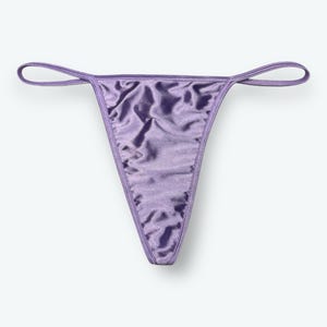 May include: A lavender-colored thong made of a shiny, silky material. The underwear has a classic thong design with thin straps and a triangular front and back.